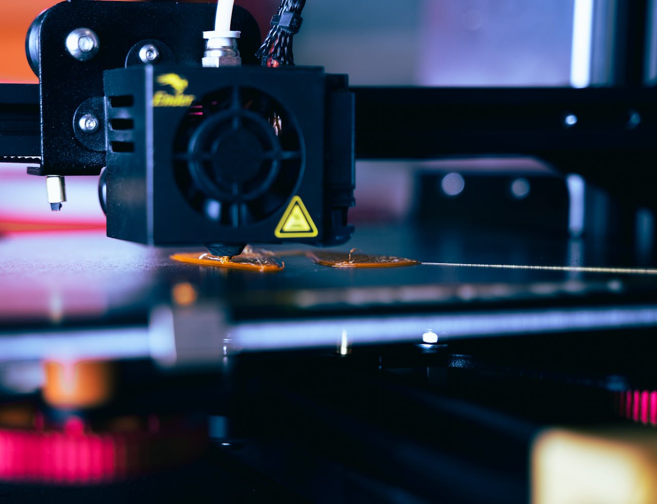services-01 Detailed view of a 3D printer head during operation, showcasing modern printing technology.